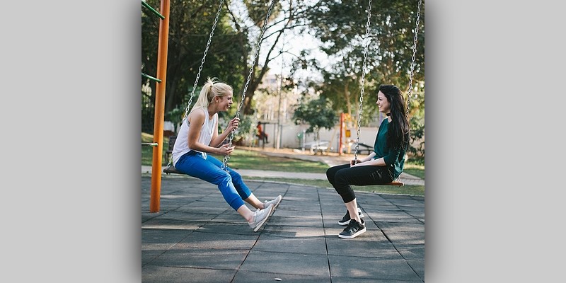 Dwie młode dziewczyny rozmawiające ze sobą w parku
